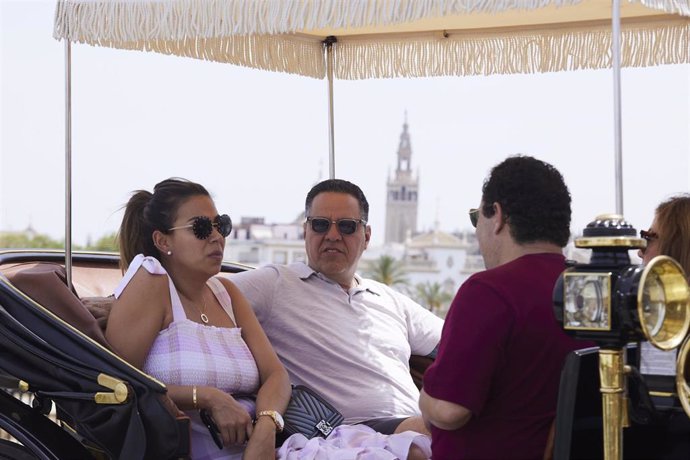 Una pareja pasea en coche de caballos bajo el toldo del mismo durante el primer día de altas temperaturas en Sevilla, a 19 de mayo de 2022 en Sevilla (Andalucía, España)