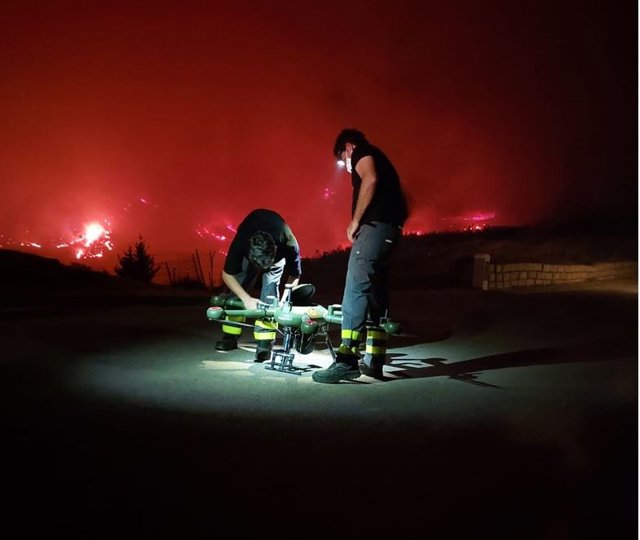 Dos efectivos con un dron que sobrevuela la zona del incendio de Pujerra (Málaga), declarado el 8 de junio de 2022