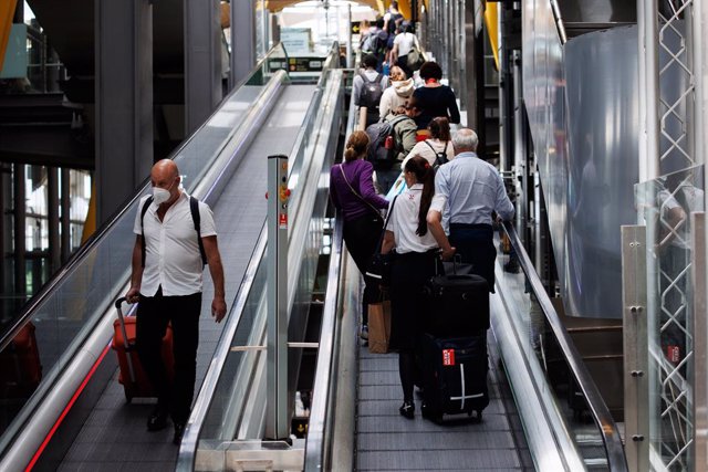 Varias personas con maletas en una de las escaleras mecánicas de la Terminal 4 (T4) del aeropuerto Adolfo Suárez Madrid-Barajas, a 8 de junio de 2022, en Madrid, (España).  