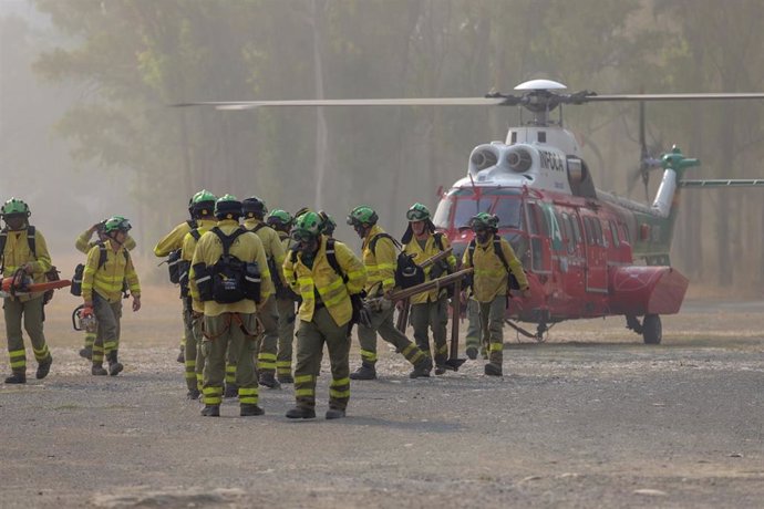 Bomberos que han estado trabajando toda la noche en el incendio forestal del Pujerra, llegan en helicóptero al puesto de mando a 09 de junio del 2022 en Pujerra (Málaga, Andalucía, España)