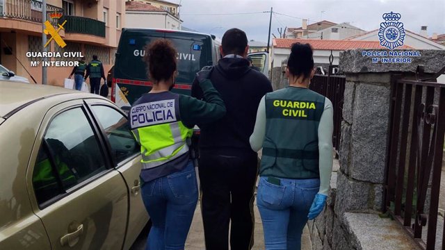 Dos agentes conducen a uno de los detenidos