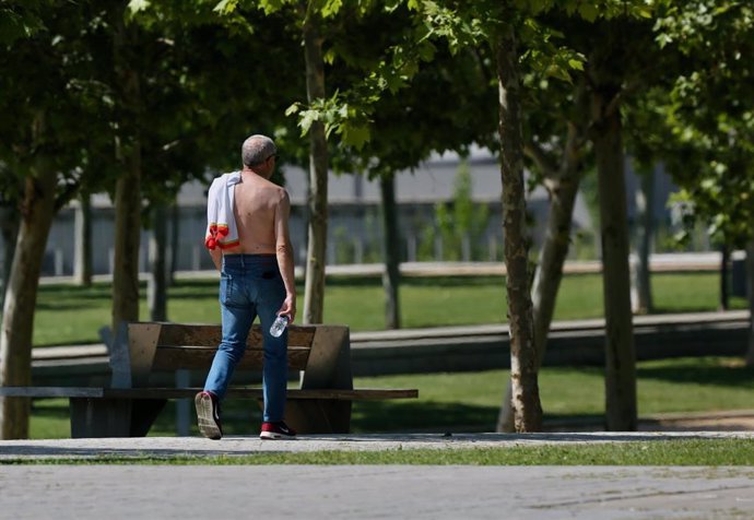 Un hombre camina sin camiseta el día en que España ha comenzado a sufrir un "importante" episodio cálido con temperaturas de pleno verano, a 17 de mayo de 2022, en Madrid (España). Algunas zonas de la península rozarán los 40 grados centígrados y noches