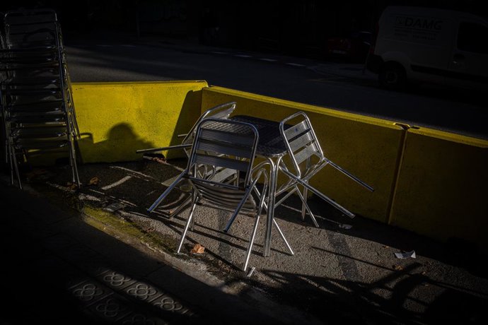 Archivo - Cadires buides en una terrassa d'un carrer de Barcelona