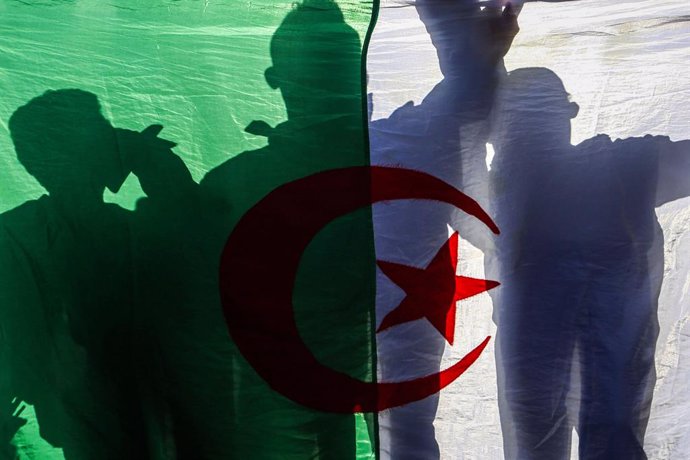 Archivo - 05 March 2021, Algeria, Algiers: Algerian demonstrators hold a national flag as they march during an anti-government protest as part of a renewed momentum to the mass demonstrations, commonly known as the Hirak Movement, that pushed long-time 