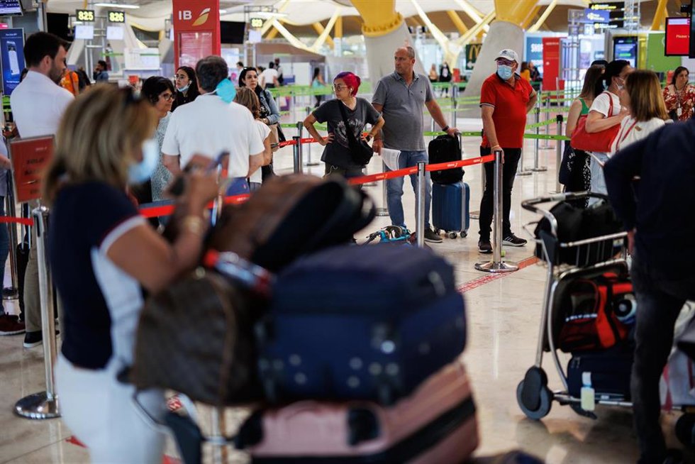 Varias personas con maletas hacen cola en la Terminal 4 (T4) del aeropuerto Adolfo Suárez Madrid-Barajas, a 8 de junio de 2022, en Madrid, (España). El Gobierno ha anunciado que los 200 agentes de la Policía Nacional tienen previsto llegar al aeropuerto
