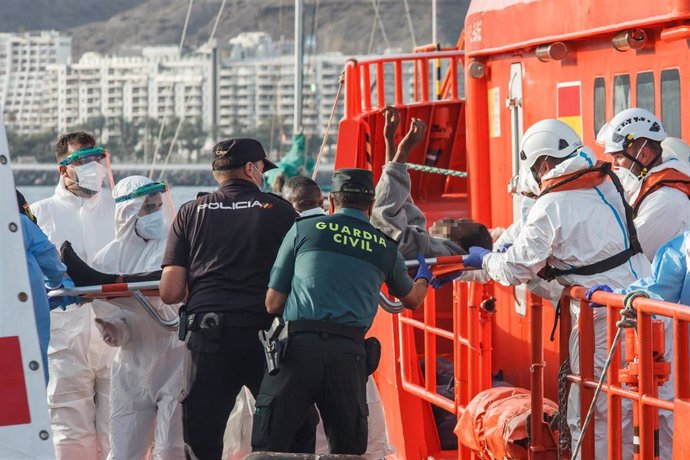 Archivo - Agentes ayudan a una persona que sale en camilla de la embarcación 'Guardamar Talía a su llegada al muelle de Arguineguín con varias decenas de migrantes, a 28 de agosto de 2021, en Arguineguín, Mogán, Gran Canaria, (España). El muelle de Arg