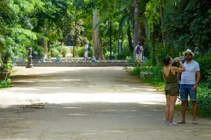 Una pareja bebe agua en  el Parque de Maria Luisa  en la primera ola de calor con temperaturas que sobrepasaran los 40 grados a 12 de junio del 2022 en Sevilla (Andalucía, España)
