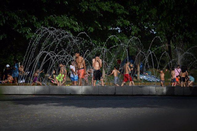 Grupos de personas disfrutan en las fuentes de Madrid Río, a 12 de junio de 2022