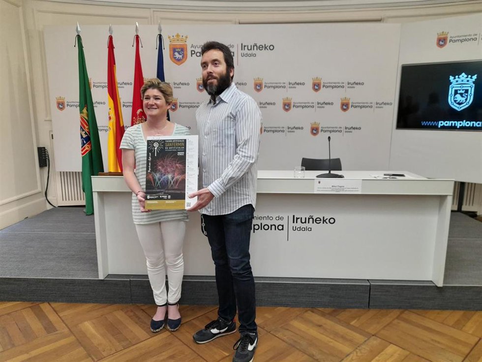 La concejala delegada de Cultura e Igualdad del Ayuntamiento de Pamplona, María García-Barberena, y el director artístico del concurso, Mikel Pagola, posan con el cartel del XXI Concurso Internacional de Fuegos Artificiales de San Fermín