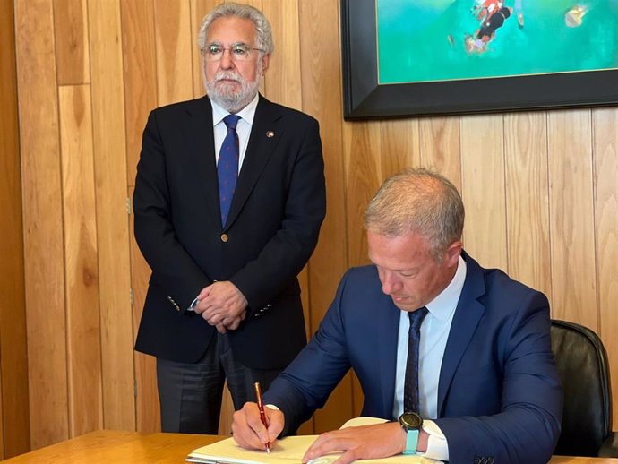 El presidente del Senado, Ander Gil,firma en el libro de honor del Parlamento de Galicia, junto a su presidente, Miguel Santalices