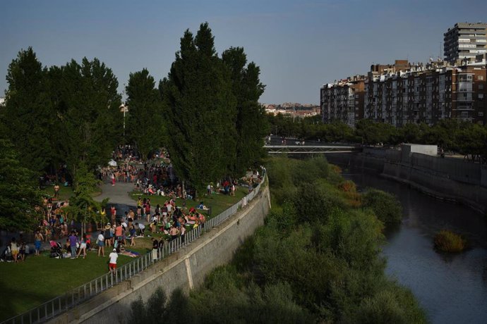 Grupos de personas disfrutan en el césped de las zonas de Madrid Río, a 12 de junio de 2022, en Madrid (España). La llegada de la primera ola de calor del verano de 2022 ha puesto en riesgo a varias comunidades por temperaturas máximas altas o muy altas