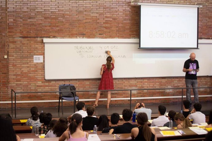 Una profesora escribe en la pizarra antes de comenzar uno de los exámenes de las pruebas de acceso a la universidad del año 2022 en Cataluña, en la Facultad de Economía y Empresa de la UB