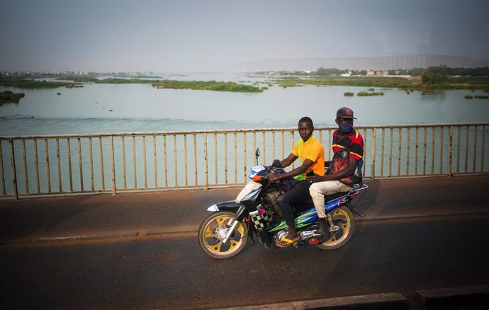 Archivo - 12 de abril de 2022, Malí, Bamako: Unos motociclistas atraviesan Níger mientras el convoy de vehículos que transporta al ministro de Asuntos Exteriores alemán pasa por Bamako, en Malí. Foto: Kay Nietfeld/dpa