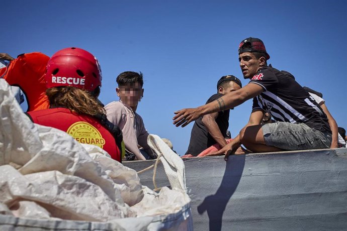 Archivo - Miembros de la ONG Open Arms y que viajan en el barco 'Astral' entregan chalecos salvavidas a varios migrantes que viajan en una patera, a 8 de septiembre de 2021, en el Mar Mediterráneo, en las inmediaciones de Lampedusa, Sicilia (Italia). El