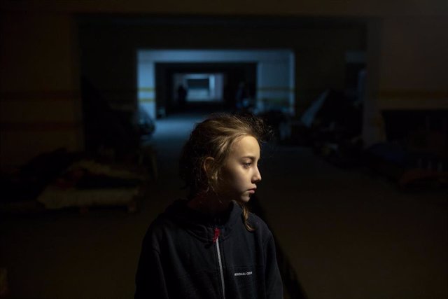 Caso: Alina, de 9 años, de la ciudad nororiental de Kharkov, está parada en un estacionamiento subterráneo, donde ella, sus padres y varias otras familias se han refugiado de los ataques aéreos y los bombardeos.