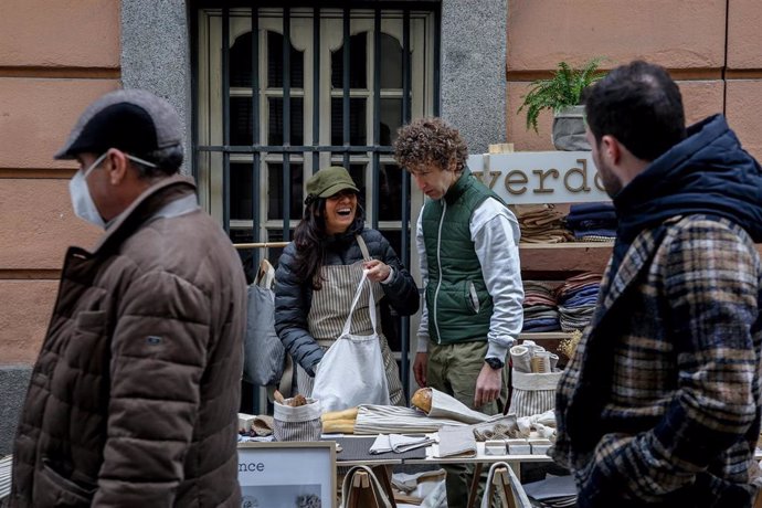 Archivo - Dos dependientes en un puesto en el mercado de las Ranas, en Madrid, en una imagen de archivo. 