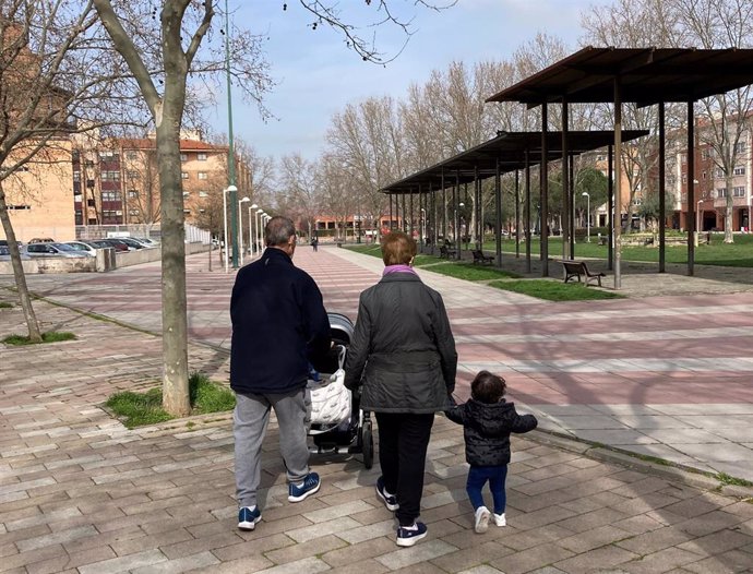 Dos abuelos pasean con su nieta en Valladolid.