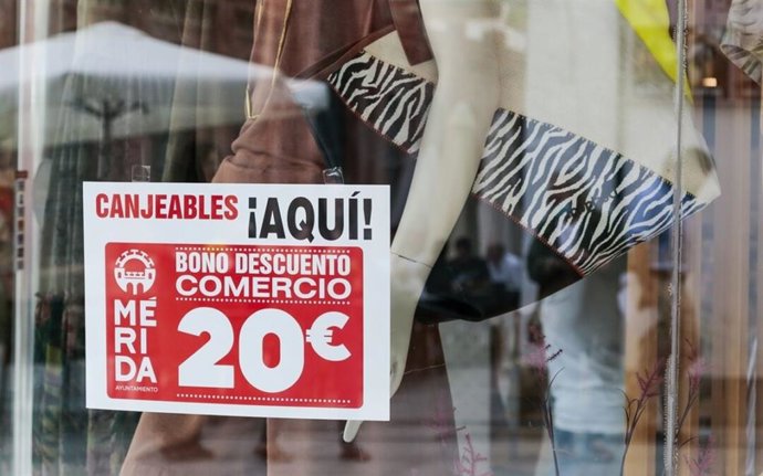 Un cartel de la campaña de bonos de 20 euros de descuento en un comercio de Mérida.