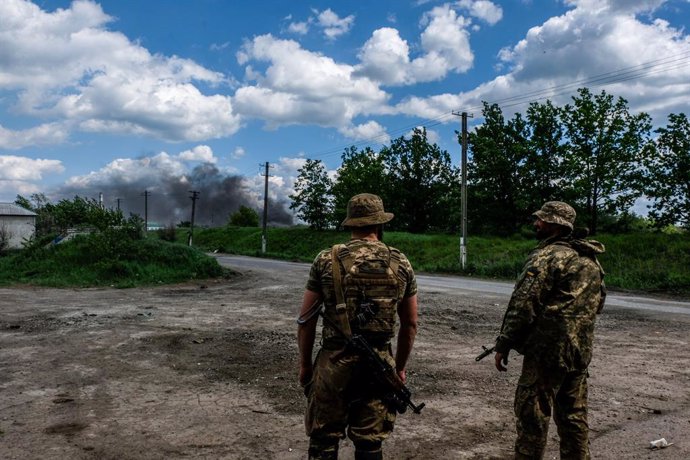 May 27, 2022, Lysychans'k, Ukraine: Soldiers looks at the smoke coming from the oil refinery of Lysychans'k. Lysychans'k is an elongated city on the high right bank of the Donets River in the Luhansk region. The city is part of a metropolitan area that 