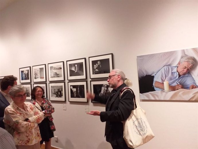 La alcaldesa de Gijón, Ana González, atiende a las explicaciones del fotógrafo Daniel Mordzinski, durante la inauguración de su exposición en el  Centro de Cultura Antiguo Instituto, Gijón