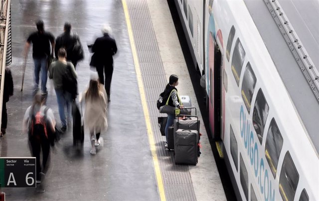 Archivo - Varias personas, con maletas, en el andén antes de coger un tren de alta velocidad en la estación Madrid - Puerta de Atocha