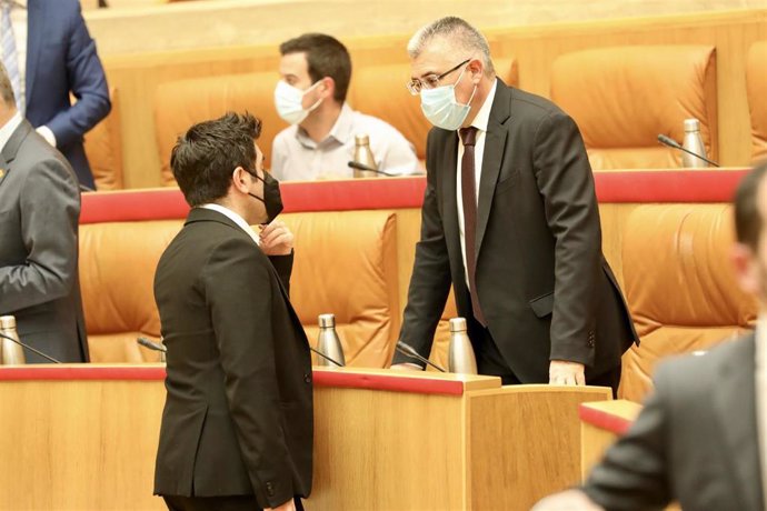 Archivo - El consejero Jose Ángel Lacalzada habla antes del pleno del Parlamento con el consejero Alex Dorado