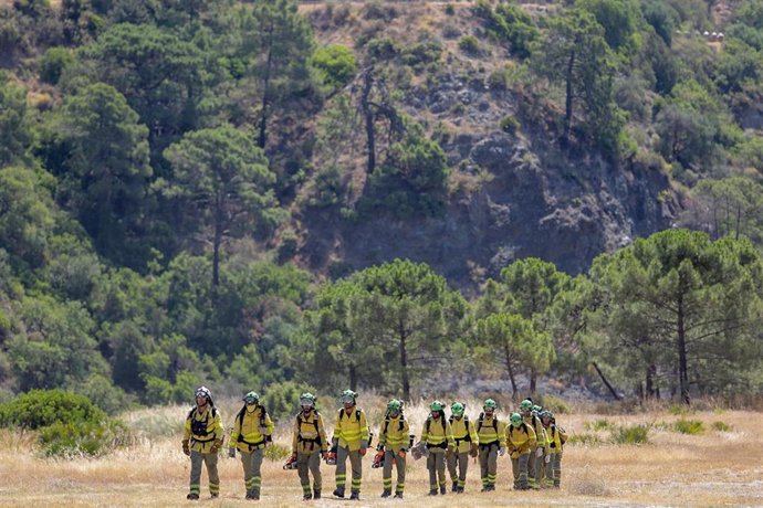 Bomberos que han estado trabajando toda la noche en el incendio forestal del Pujerra, llegan en helicóptero al puesto de mando a 09 de junio del 2022 en Pujerra (Málaga, Andalucía, España)