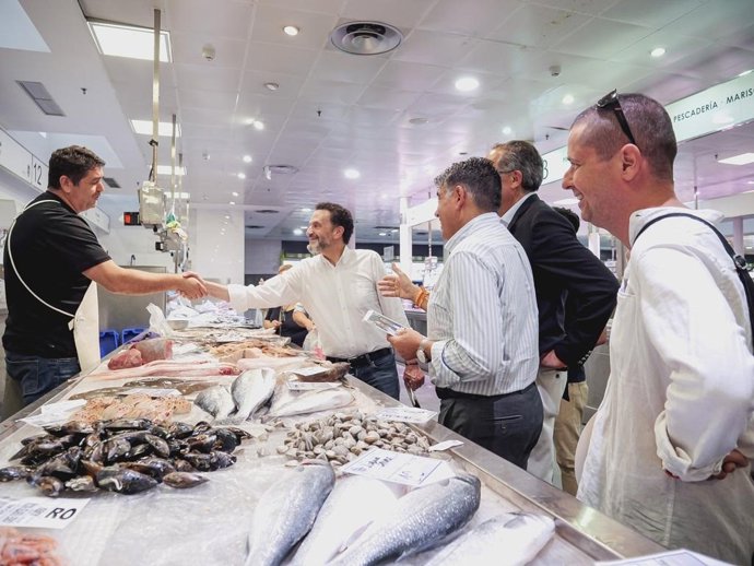 El vicesecretario general de Cs, Edmundo Bal, saluda a un pescadero en el Mercado Central de Almería.