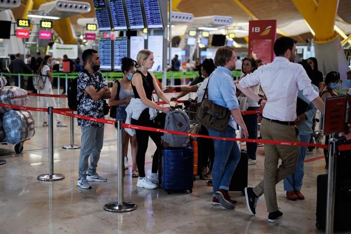 Varias personas con maletas hacen cola en la Terminal 4 (T4) del aeropuerto Adolfo Suárez Madrid-Barajas, en Madrid (España). 
