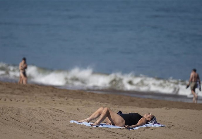 Archivo - Varias personas pasean y toman el sol en la Playa de Ereaga en Getxo 