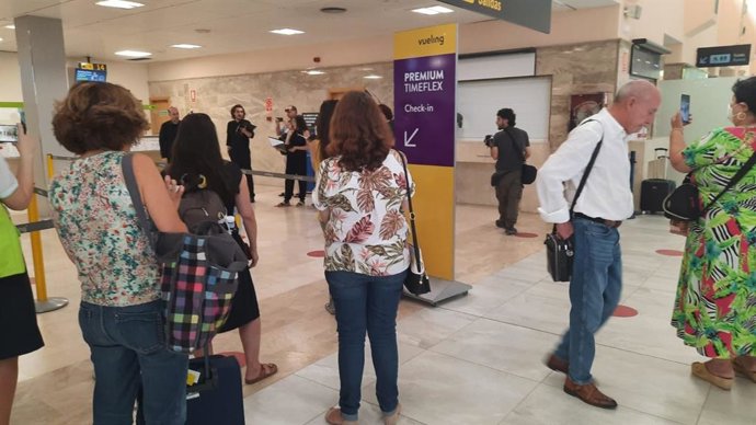 Pasajeros presencian el concierto coral en el aeropuerto.