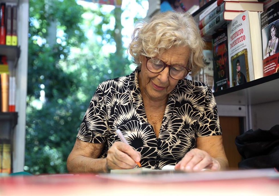 La exalcaldesa de Madrid, Manuela Carmena, firma libros en una caseta de la Feria del Libro 2022.