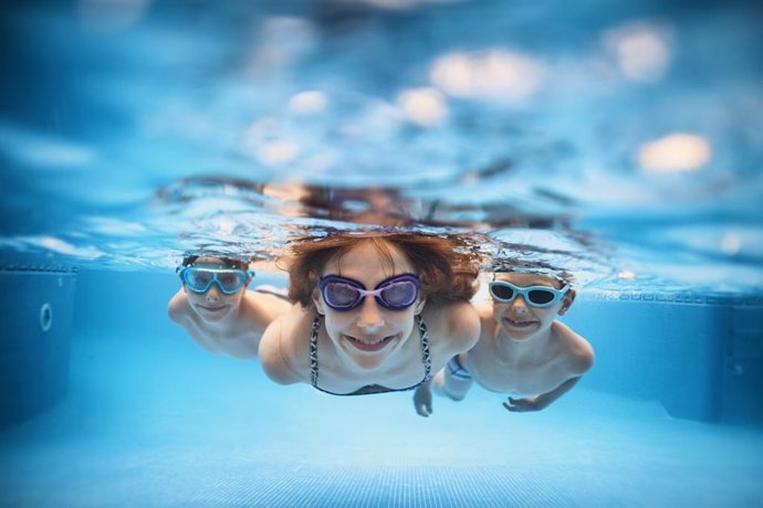 Archivo - Madre y sus hijos buceando en una piscina.