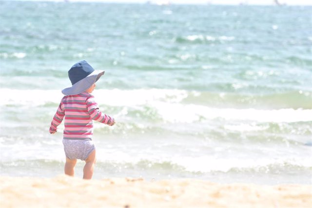 Bebé en la playa, sol, crema solar