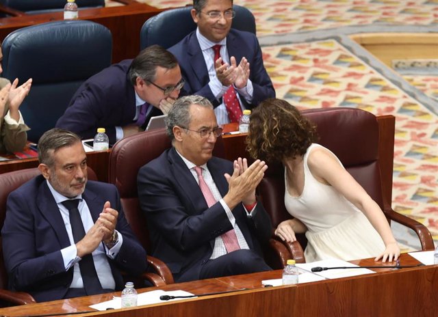 La presidenta de la Comunidad de Madrid, Isabel Díaz Ayuso,  habla con el secretario general del PP de Madrid y portavoz en la Asamblea, Alfonso Serrano, durante una sesión plenaria en la Asamblea de Madrid, a 16 de junio de 2022, en Madrid (España)