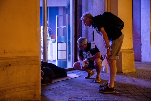Dos voluntaris s'interessen per una persona durant l'elaboració del cens de persones en situació de sensellarisme