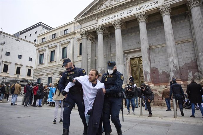 Archivo - Un manifestante es desalojado, en una acción de desobediencia para pedir más ambición en la lucha contra el calentamiento, de La Puerta del Congreso de los Diputados, a 6 de abril de 2022, en Madrid (España). 