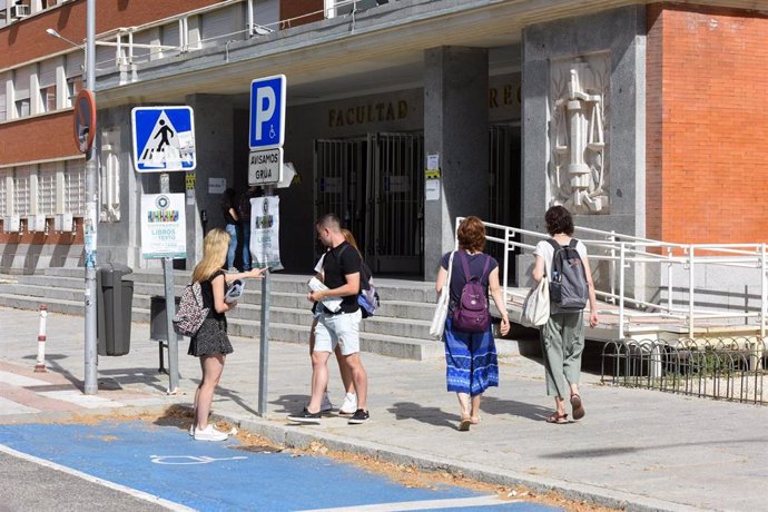 Varias personas en la entrada de la Facultad de Derecho.