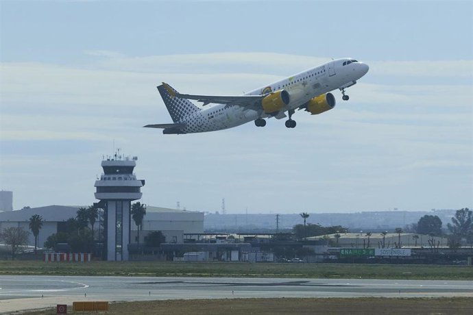 Archivo - Un avión despega y al fondo la torre de control del Aeropuerto de Sevilla, en una imagen de archivo