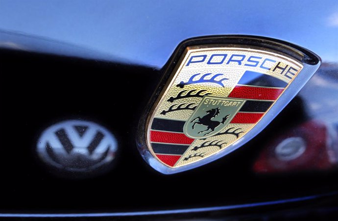 Archivo - FILED - 05 July 2012, Bavaria, Kaufbeuren: A general view of a Porsche logo on a vehicle next to a reflection of the Volkswagen logo. The Volkswagen Group is apparently moving forward on its plans to list its sports car subsidiary Porsche on t