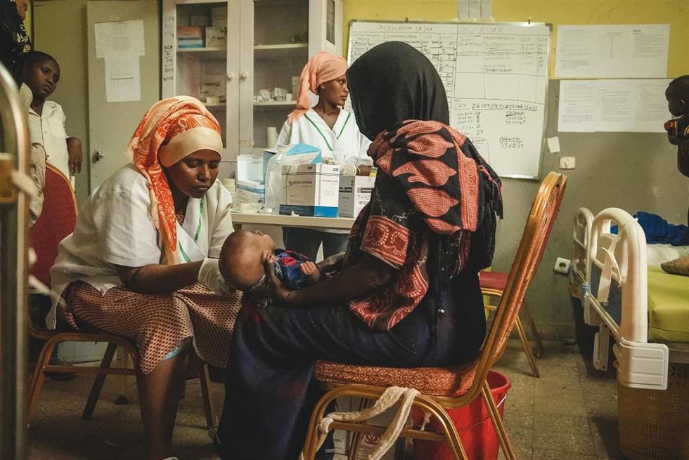 Personal del Ministerio de Salud en el hospital midiendo la circunferencia del brazo medio superior de un niño durante un examen de desnutrición en el centro de alimentación terapéutica para pacientes hospitalizados (ITFC) en el hospital Dupti