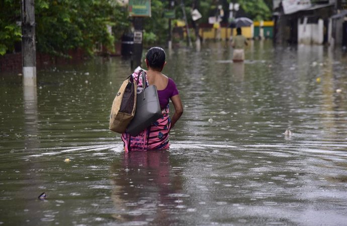 Mujer en una calle inundada en Guwahati, en el estado de Assam, India