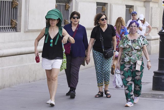 Una señora protegida con un toldo para combatir el Sol durante el primer día de altas temperaturas en Sevilla, a 19 de mayo de 2022 en Sevilla (Andalucía, España)
