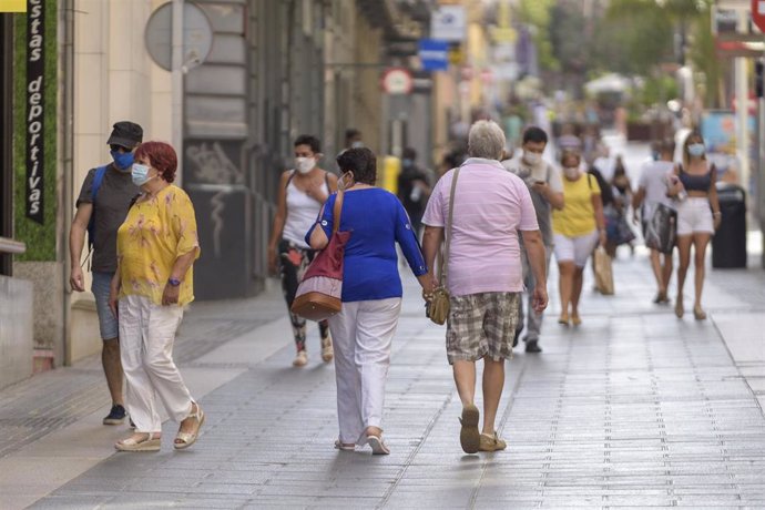 Archivo - Personas con mascarilla paseando por la calle