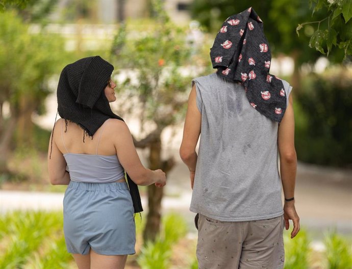 Dos personas con la cabeza tapada pasean por la calle