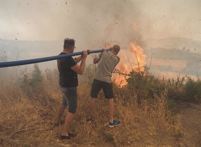 Vecinos intervienen en la extinción del  incendio declarado en Obanos, a 18 de junio de 2022, en Obanos, Pamplona, Navarra, (España)