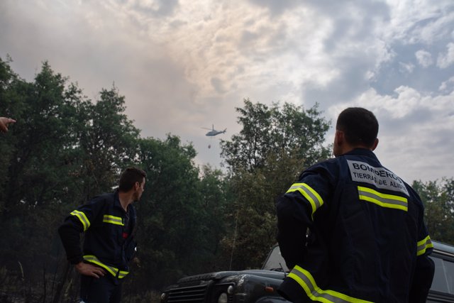 Dos bomberos observan un helicóptero trabajando en el incendio de la Sierra de la Culebra, a 17 de junio de 2022, en Zamora, Castilla y León (España). 