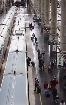 Archivo - Viajeros con maletas suben a un tren en la Estación Puerta de Atocha, a 13 de abril de 2022, en Madrid (España). 