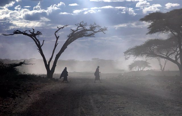 Archivo - Dos masai cruzan una carretera en el Parque Nacional Serengeti, en Tanzania