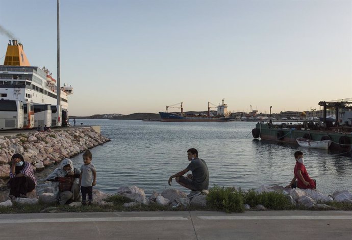 Archivo - 29 September 2020, Greece, Lavrio: Refugees from Greek islands camps sit in the port of Lavrio after arriving on a ferry to be transferred to camps in mainland Greece. Greek authorities moved about 1000 migrants, mostly families and recognised